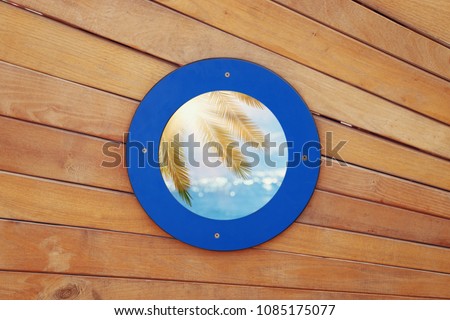 picture of old ship door with a round blue window