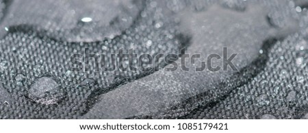 Closeup detailed view of raindrops on a fabric, a background.