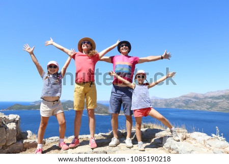 family with two daughters travels through the beautiful mountains above the blue sea