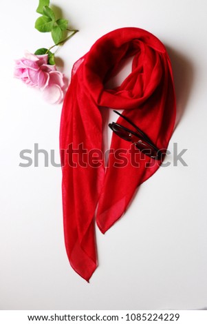 Red beautiful scarf and black summer glasses separated on white background with rose. Royalty-Free Stock Photo #1085224229