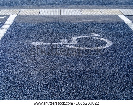 ?Handicapped parking sign or symbol painted on asphalt texture.