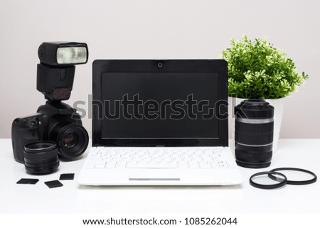 set of modern photography equipment and white laptop on the table