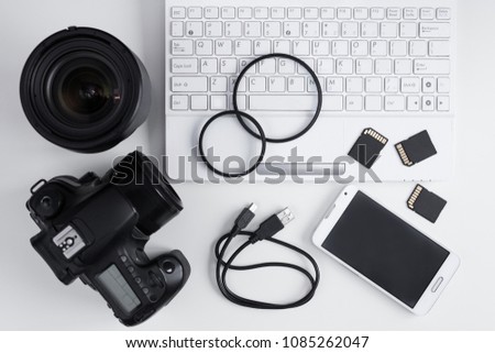 top view of camera, lenses, photo equipment and laptop over white table background
