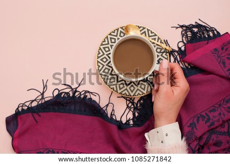 Women hand holding coffee. Latte in a white, black and gold coffee cup. Feminine workplace concept. Freelance fashion comfortable femininity workspace with coffee. Bright pink and purple background.