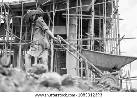 Little girl labor working in commercial building structure, World Day Against Child Labour concept. Royalty-Free Stock Photo #1085312393