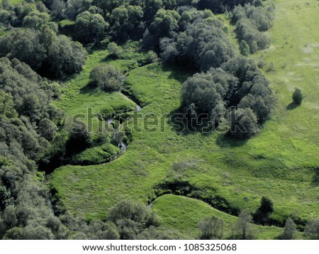 Spring green meadow and small river. Russia, aerial photograph. Green summer meadow, river.