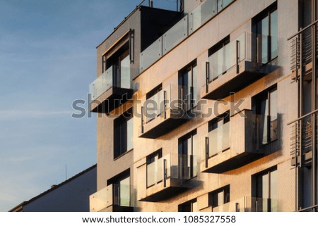 Golden facade of a multistorey building with balconies, background at the sunset
