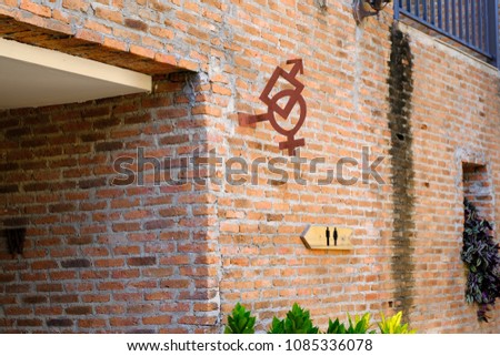 The toilet sign guide post symbol  hanging in the brick wall