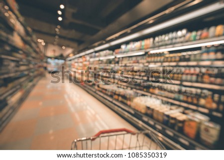 Defocused blur of supermarket shelves with alcohol products cart. Blur background with bokeh. Defocused image