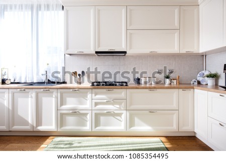 Modern kitchen interior design with white furniture and modern details Royalty-Free Stock Photo #1085354495