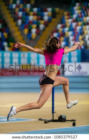Female Athlete during her triple jump attempt.  Royalty-Free Stock Photo #1085379527