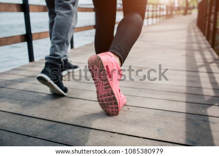 Close up of jogger's feet. There are man's and woman's feet on the picture. Cut view.