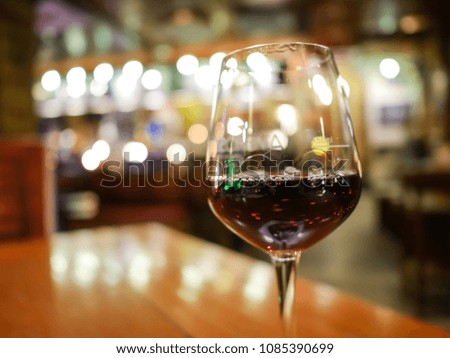 Red wine in the glass. Beautiful  light bokeh background in bar