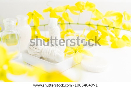 Bright spa background: candles and thai massage herbal bags with bottles and yellow flowers on white. Health, skin treatment concept Royalty-Free Stock Photo #1085404991