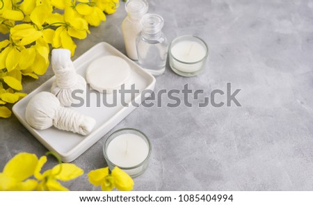 Bright spa background: candles and thai massage herbal bags with bottles and yellow flowers on ????. Health, skin treatment concept? ???? ????? Royalty-Free Stock Photo #1085404994