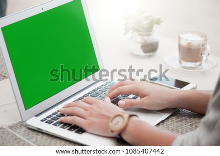 Happy woman using laptop at cafe. Young beautiful girl sitting in a coffee shop and working on computer Royalty-Free Stock Photo #1085407442