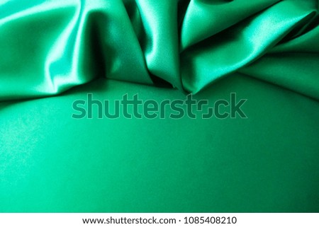 Beautiful smooth elegant wavy green satin silk luxury cloth fabric texture, abstract background design. Card or banner.