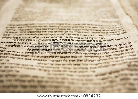 Hebrew text from a portion of a Torah scroll. This scroll is estimated to be 150 years old and is wrinkled and spotted with age. This view has tight selective focus on just one line on the page. Royalty-Free Stock Photo #10854232