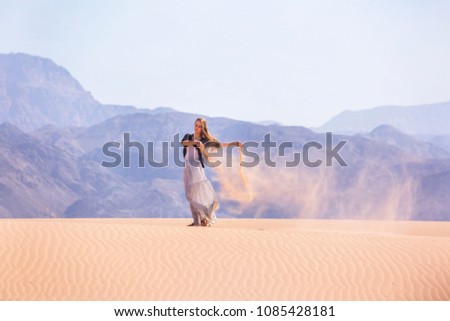 Woman standing on a sand dune in the desert of Jordan