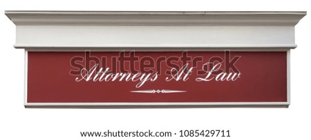 Building detail of ATTORNEYS AT LAW sign: white cursive script on brown background.