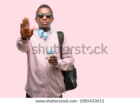 African black man student annoyed with bad attitude making stop sign with hand, saying no, expressing security, defense or restriction, maybe pushing