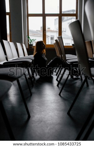 Business woman stay  in modern office meeting room. Busines lady stay near many chairs in empty conference hall. Woman waiting for conference.