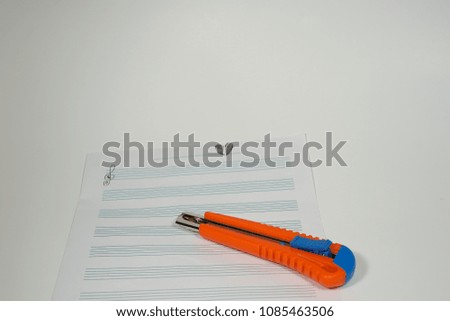 Cutter and staff music on white background