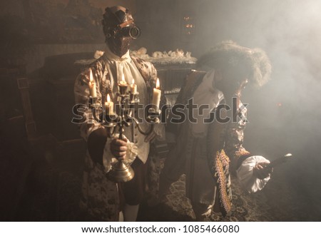 Actors in steam punk masks and antique costumes indoor.