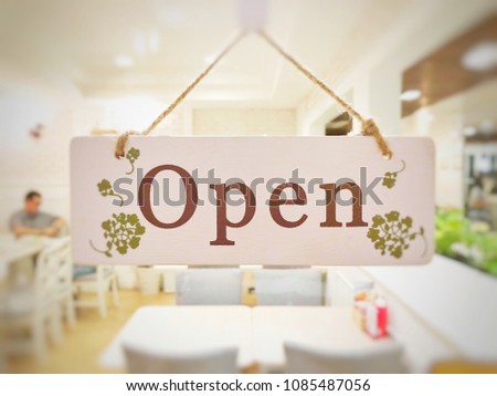 The wooden page and sign wording "Open" in the front of restaurant.