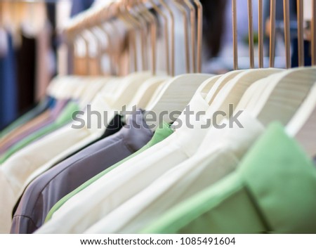 Many of Colored Shirts on hangers in row. Sale of t-shirt business men hang on the clothes line on street night market in bangkok of thailand. - Selective focus.