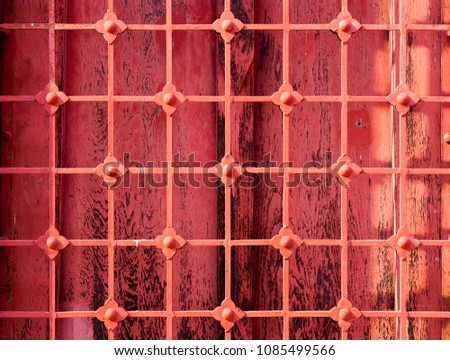 Closeup picture old red wooden window of thai temple and red wrought iron thai style are installed to prevent theft