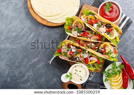 Traditional Mexican tacos with meat and vegetables on gray background. top view.
