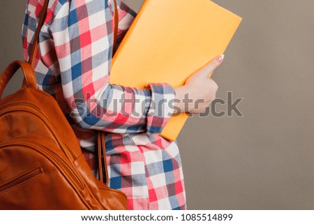 A student woman is holding a blackboard on a gray background. woman and way of life