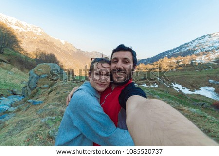 Travelers couple in love enjoying a day trekking in the Alps