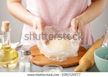 Woman wrap the dough in the package. Step by step recipe of homemade tortillas.