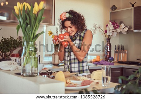 Charming curly Hispanic girl cooking in her kitchen.