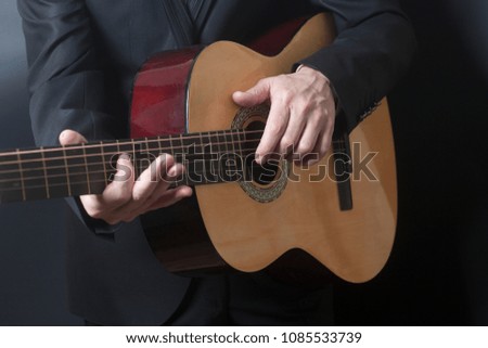Man in black suit with acoustic classic guitar