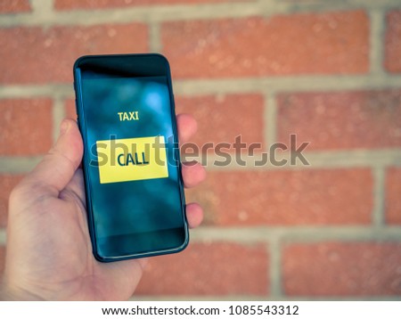 Taxi app on mobile phone. One click to order or call a cab. Bricks in background.