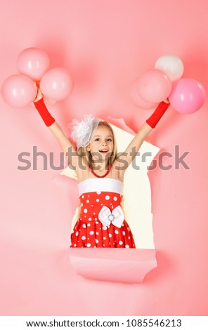 Funny little girl on background of bright pink wall. Beautiful child is having fun with balloon. pink and red colors.