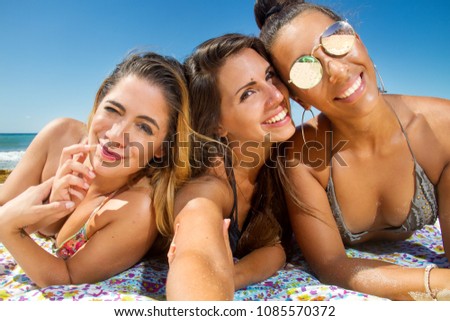 selfie photo of beautiful girls laying  on the beach