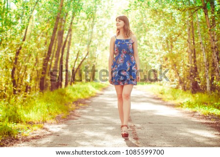 girl walking on the road between villages in sunlight