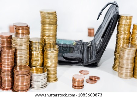 A lot of coins on white table with black purse. Abstract photo of money.