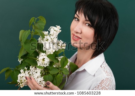 portrait of woman with lilac flowers on green blackboard background