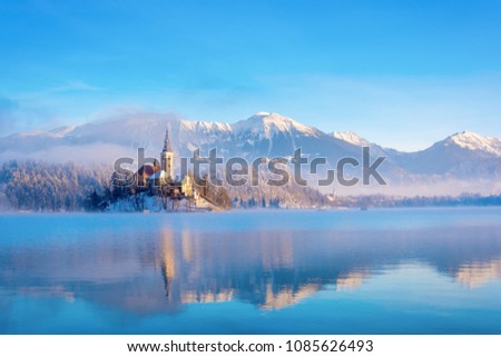 Lake bled on a winter sunny morning with clear sky and snow covering the mountains Royalty-Free Stock Photo #1085626493