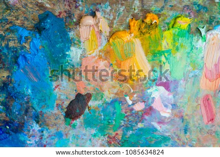 Palette with smeared paints, as a texture for design. Oil paints of different colors.