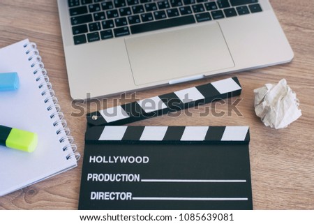 Video Editing,Movie clapper laptop and pencil notepad on the wood table top view 