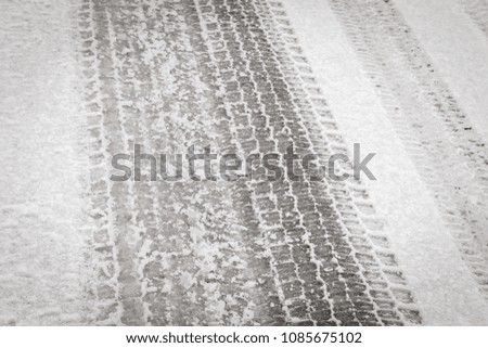 background texture of asphalt road covered with snow and tire tracks