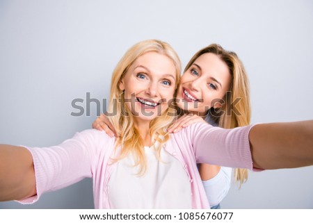 Cheerful positive charming grandma shooting self portrait with trendy stylish granddaughter having leisure casual outfits perfect mood enjoying time together isolated on grey background