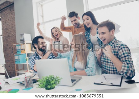 Cheerful, glad, joyful, lucky, stylish, positive, attractive economists looking at screen of laptop, computer with raised hands screaming celebrating victory giving high five to each other Royalty-Free Stock Photo #1085679551