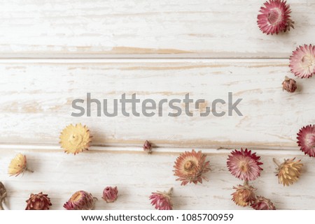Minimal styled flat lay. Straw flower on white wood table.